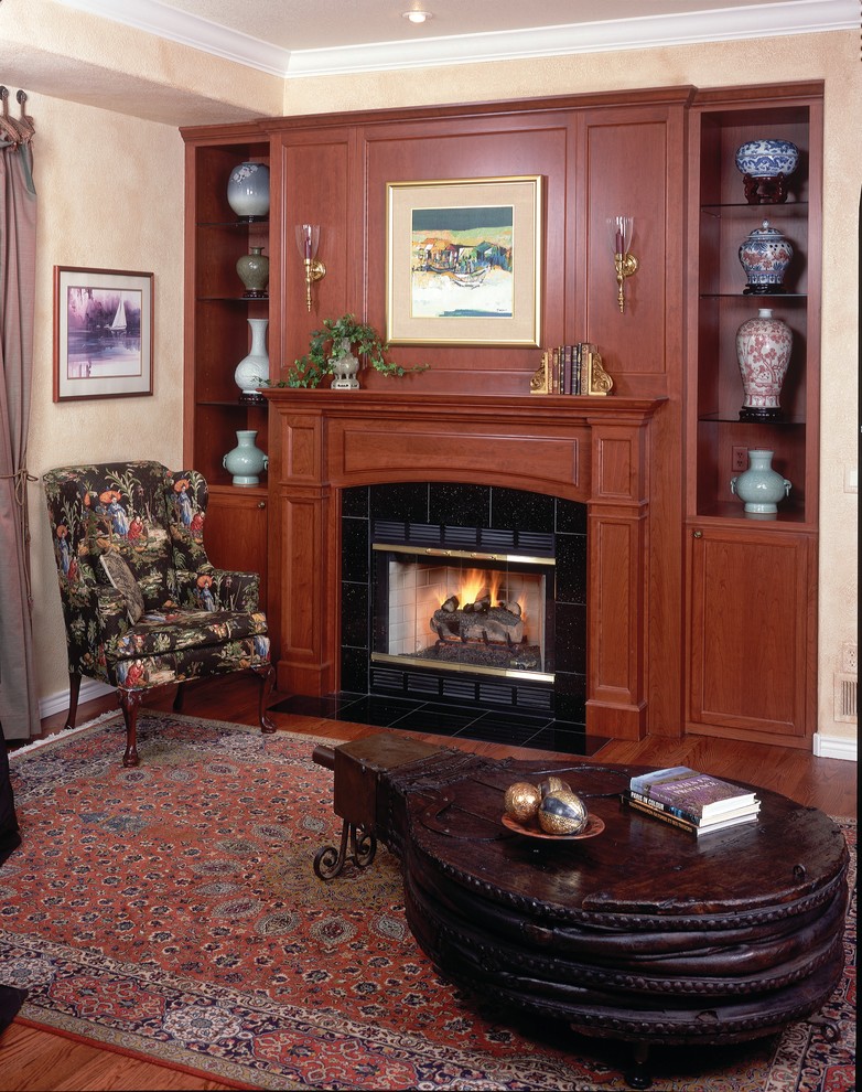 Foto de biblioteca en casa abierta clásica renovada de tamaño medio con paredes beige, suelo de madera en tonos medios, todas las chimeneas y marco de chimenea de madera