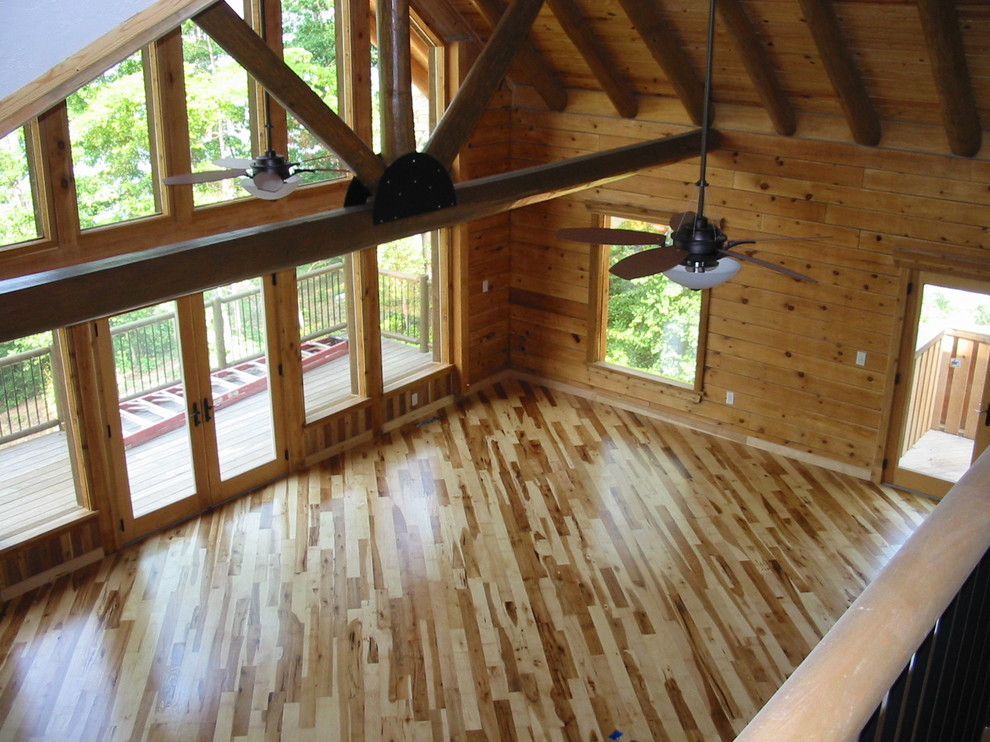 This is an example of an expansive mezzanine living room in Other with brown walls and medium hardwood flooring.