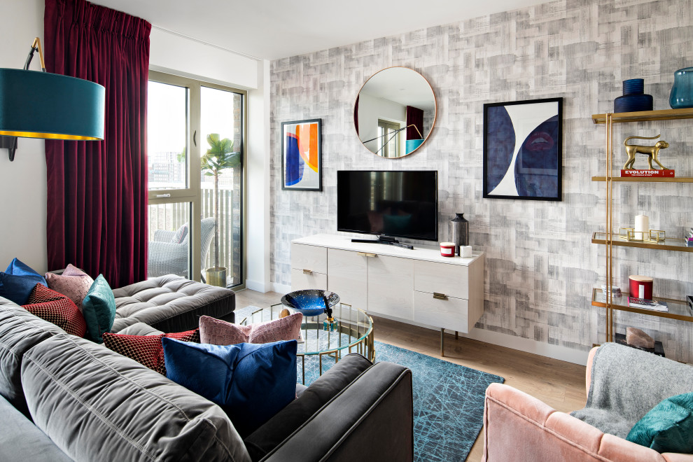 Modern inredning av ett mellanstort allrum med öppen planlösning, med vita väggar, en fristående TV, beiget golv och ljust trägolv