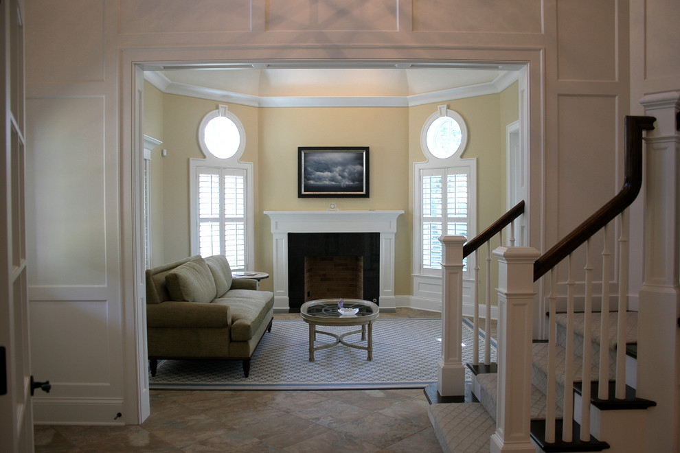 Idéer för ett mellanstort klassiskt separat vardagsrum, med gula väggar, klinkergolv i porslin, en standard öppen spis och beiget golv