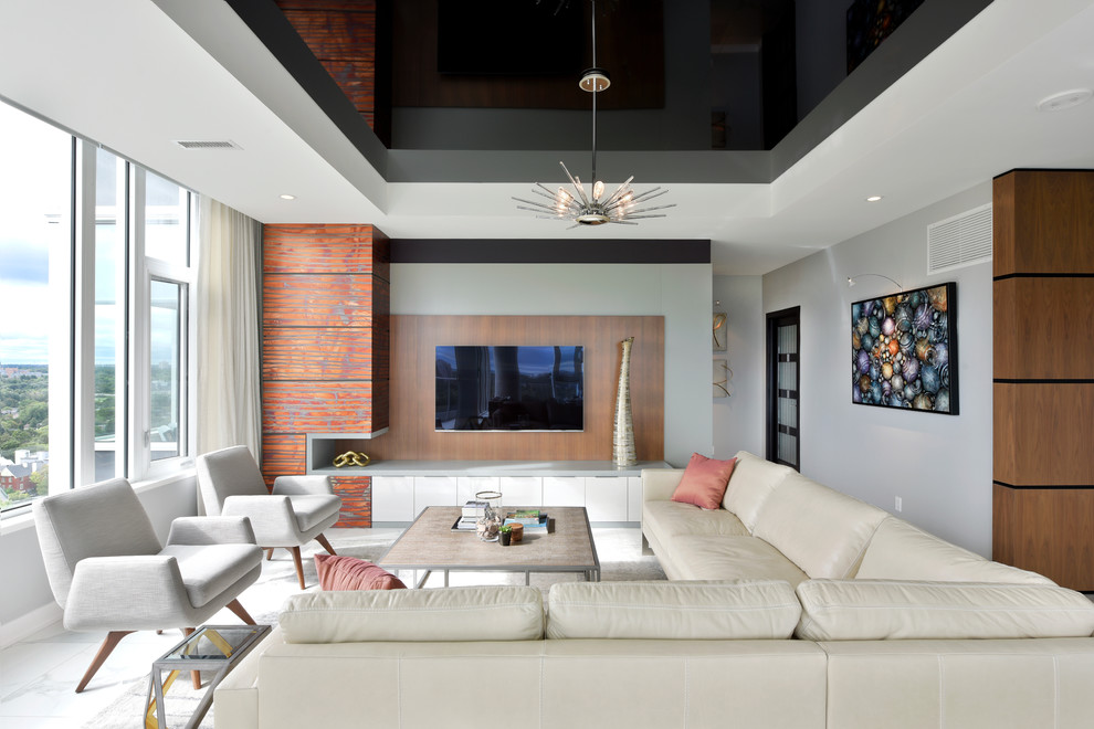 На фото: открытая гостиная комната в современном стиле с телевизором на стене, белым полом, серыми стенами и мраморным полом без камина
