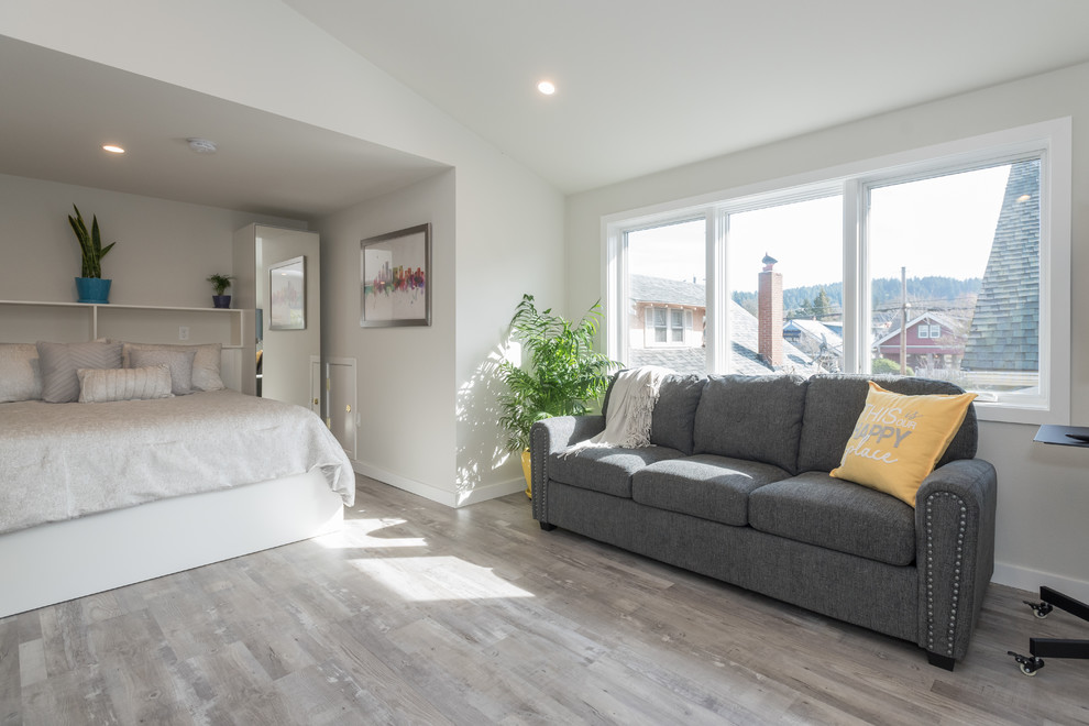 This is an example of a small contemporary open plan living room in Portland with white walls, a freestanding tv and grey floors.