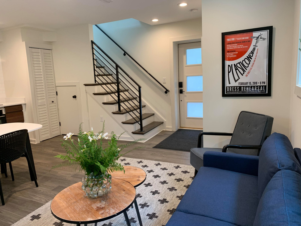 Immagine di un soggiorno minimalista di medie dimensioni e aperto con pareti bianche, pavimento in laminato e pavimento marrone