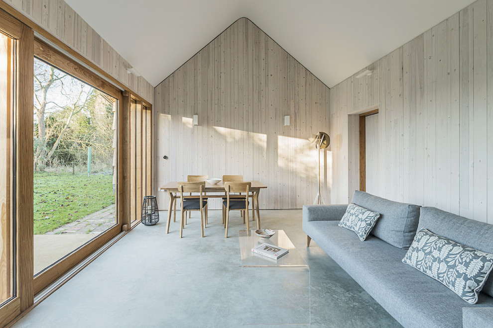 Immagine di un piccolo soggiorno design chiuso con pareti beige, pavimento in cemento e pavimento grigio