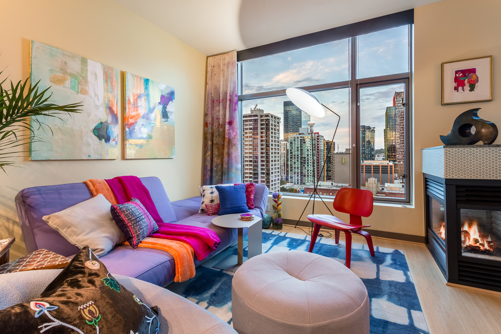 This is an example of a small eclectic open plan living room in Seattle with yellow walls, bamboo flooring, a two-sided fireplace and a tiled fireplace surround.