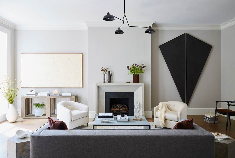 Repräsentatives Klassisches Wohnzimmer mit grauer Wandfarbe, braunem Holzboden und Kamin in New York