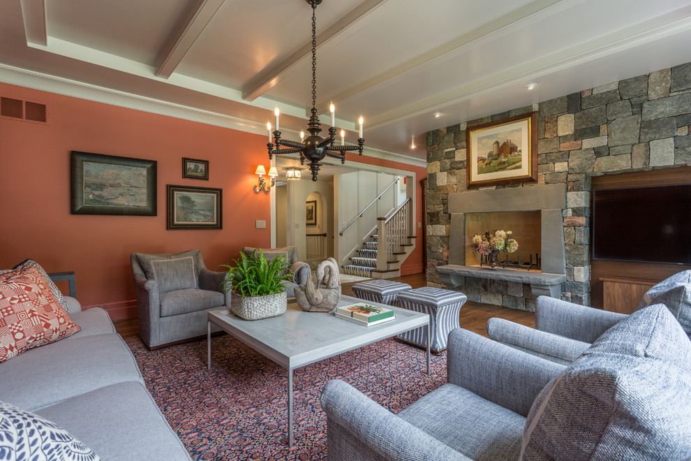Großes, Abgetrenntes Klassisches Wohnzimmer mit braunem Holzboden, Kaminumrandung aus Stein, oranger Wandfarbe, Kamin und TV-Wand in Milwaukee