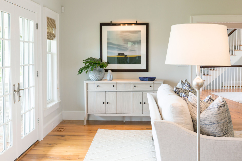 Immagine di un soggiorno stile marino di medie dimensioni e aperto con sala formale, pareti bianche, TV a parete e pavimento marrone