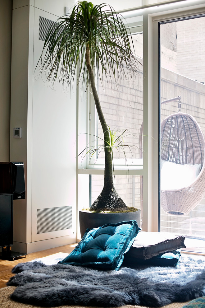 Источник вдохновения для домашнего уюта: большая двухуровневая гостиная комната в современном стиле с бежевыми стенами, паркетным полом среднего тона и телевизором на стене