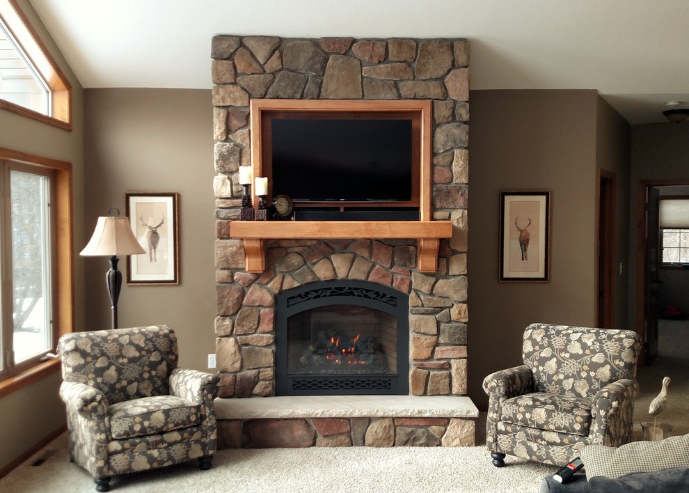 Photo of a living room in Minneapolis with beige walls, carpet, a standard fireplace, a stone fireplace surround and a wall mounted tv.