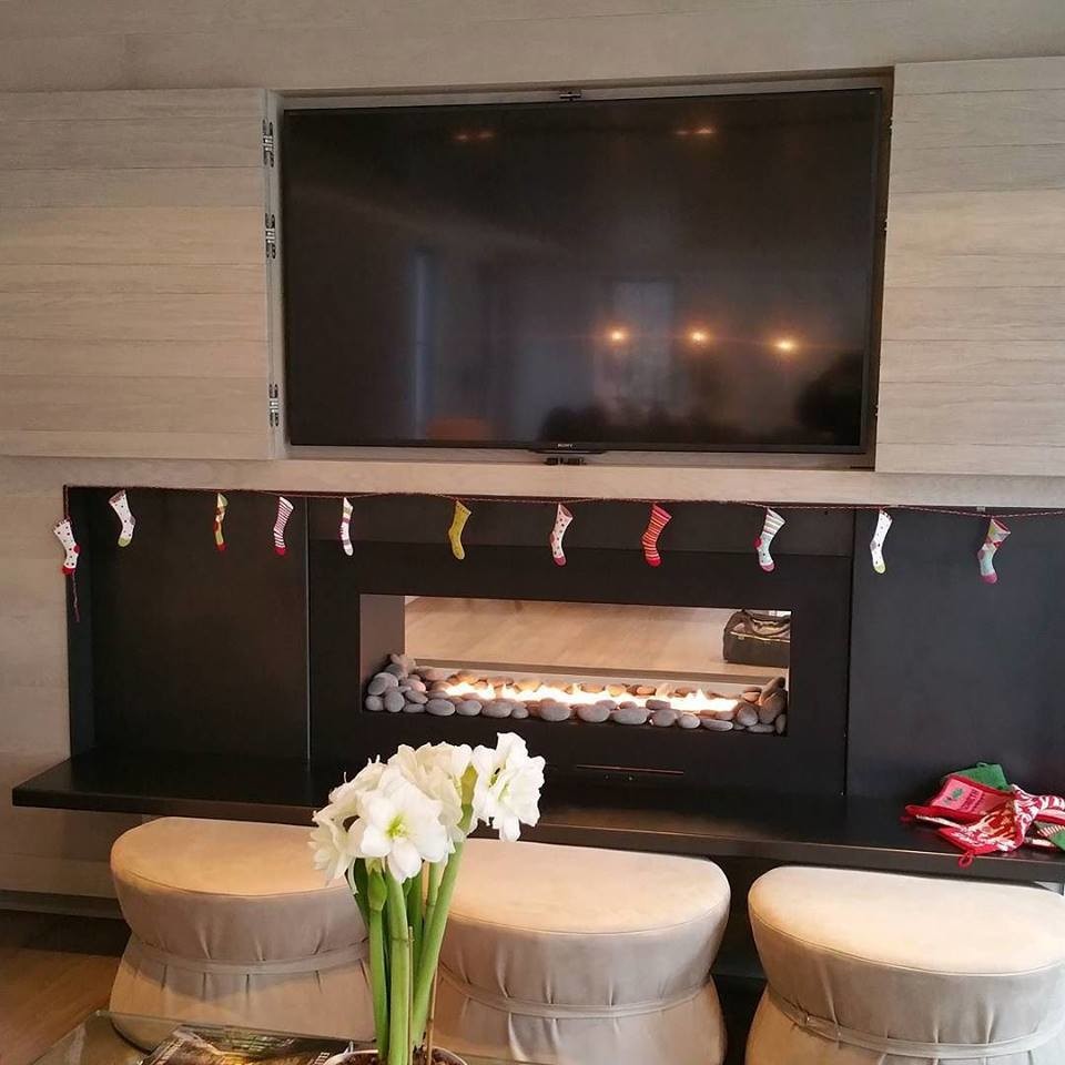 Example of a country living room design in New York with a two-sided fireplace and a metal fireplace