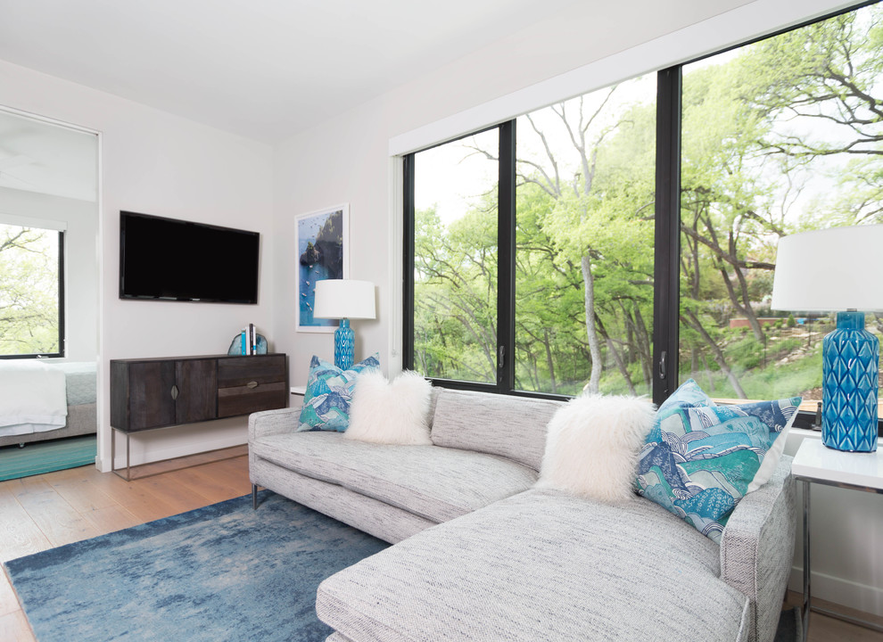 Kleines, Offenes Modernes Wohnzimmer mit weißer Wandfarbe, hellem Holzboden und TV-Wand in Austin