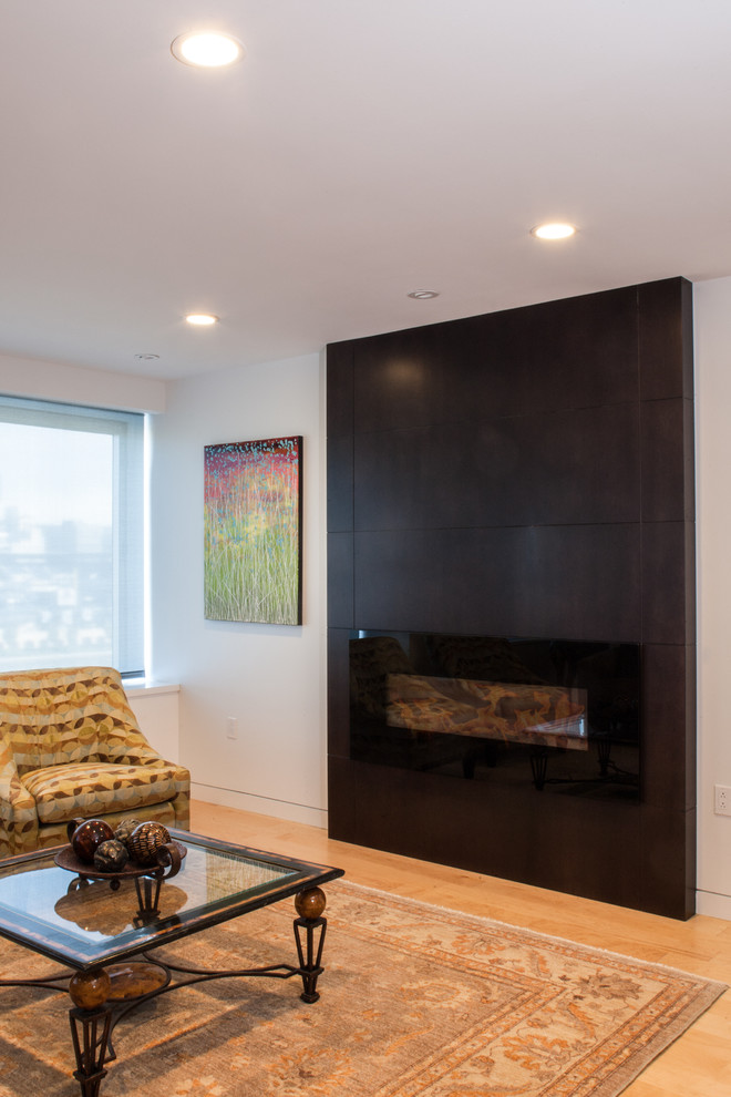 Offenes Modernes Wohnzimmer mit weißer Wandfarbe, hellem Holzboden, Gaskamin und Kaminumrandung aus Holz in Sonstige