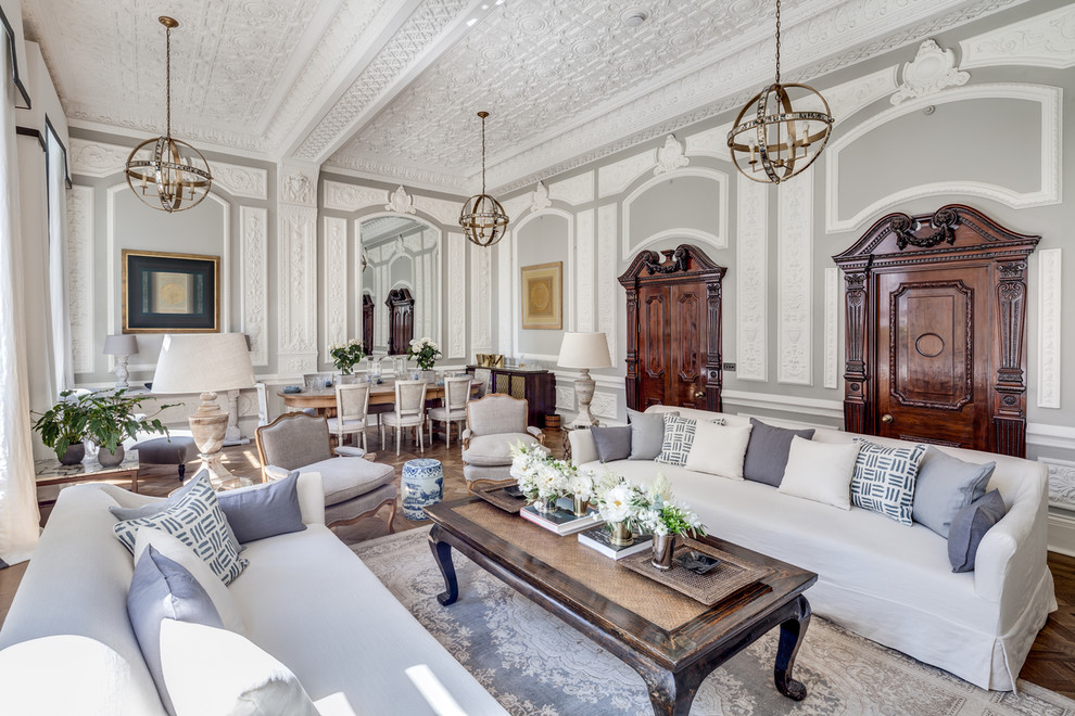 Свежая идея для дизайна: гостиная комната в стиле неоклассика (современная классика) с серыми стенами, паркетным полом среднего тона, стандартным камином и фасадом камина из дерева - отличное фото интерьера
