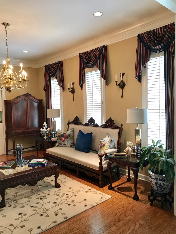 Inspiration for a victorian enclosed medium tone wood floor and brown floor living room remodel in Jackson with beige walls, no fireplace and no tv