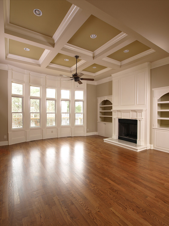 Photo of a large traditional formal open plan living room in New York with beige walls, dark hardwood flooring, a standard fireplace, a plastered fireplace surround, no tv and brown floors.
