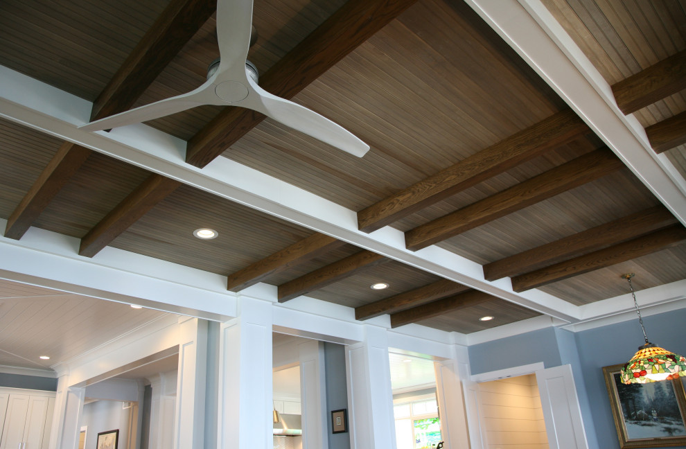 Photo of a large coastal open plan living room in Milwaukee with exposed beams and wood walls.