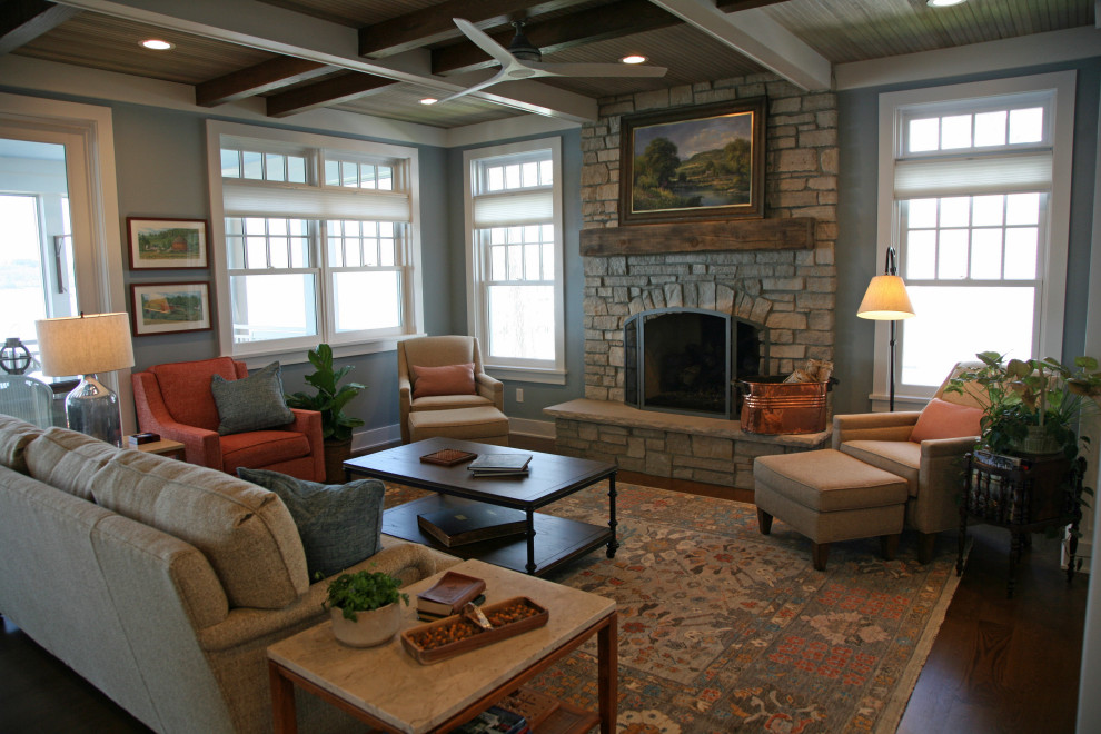 This is an example of a large beach style open plan living room in Milwaukee with blue walls, marble flooring, a standard fireplace, a stone fireplace surround, no tv, brown floors, exposed beams and wood walls.