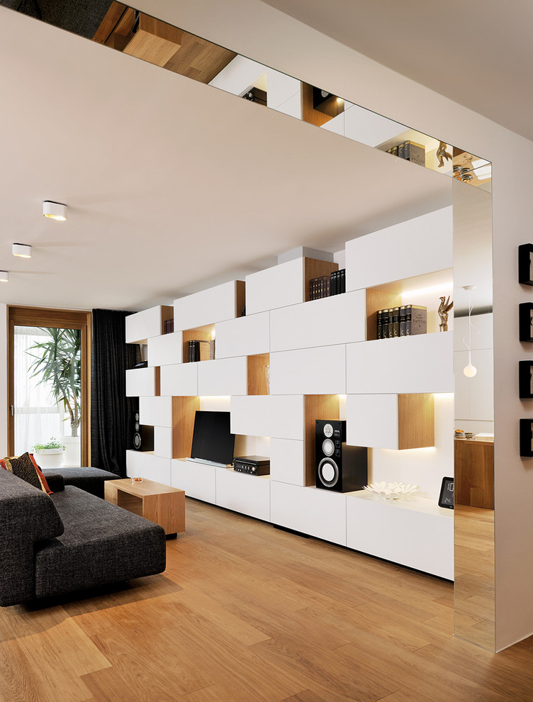 Пример оригинального дизайна: открытая гостиная комната в современном стиле с белыми стенами, паркетным полом среднего тона и отдельно стоящим телевизором
