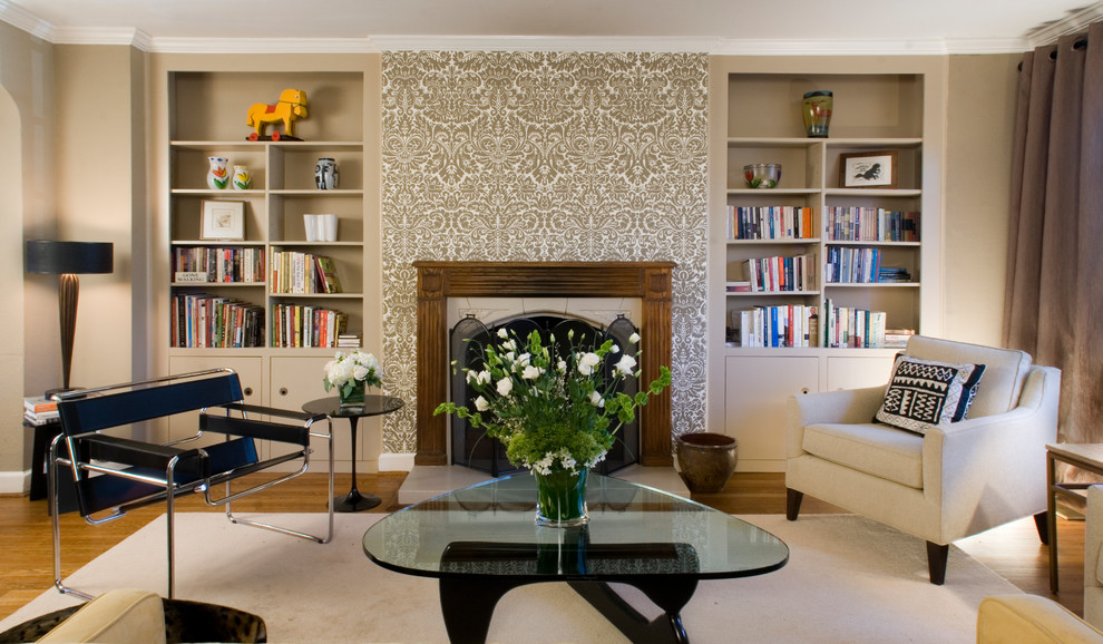 Immagine di un soggiorno chic con pareti beige, libreria e camino classico