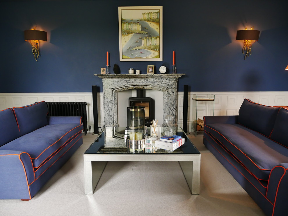Пример оригинального дизайна: большая парадная, изолированная гостиная комната в классическом стиле с синими стенами, ковровым покрытием, печью-буржуйкой, фасадом камина из камня, телевизором на стене и серым полом