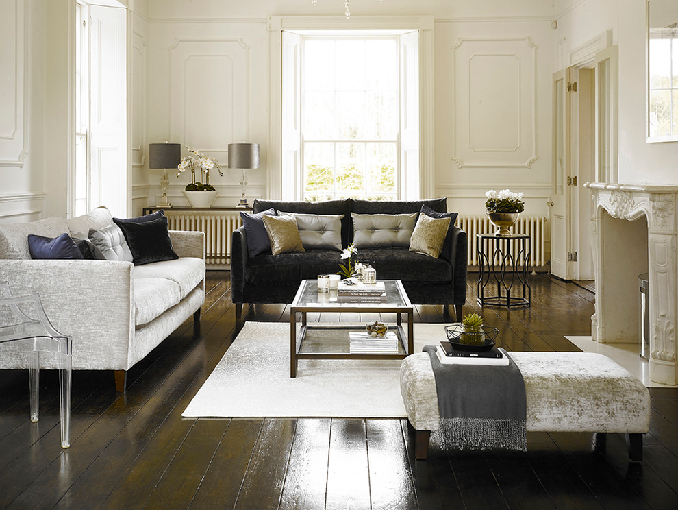 Klassisches Wohnzimmer mit weißer Wandfarbe, dunklem Holzboden und verputzter Kaminumrandung in Hertfordshire