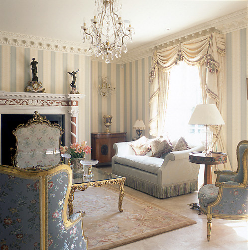 На фото: большая парадная гостиная комната в классическом стиле с серыми стенами, мраморным полом, фасадом камина из штукатурки и стандартным камином