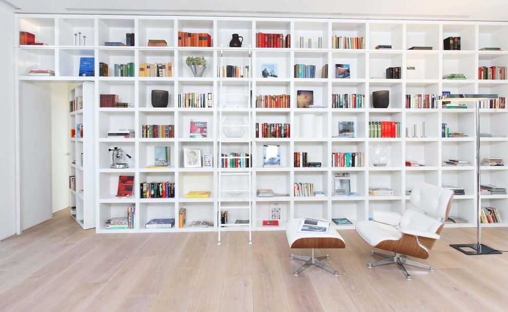 Idées déco pour un salon moderne avec une bibliothèque ou un coin lecture, parquet clair et un sol beige.