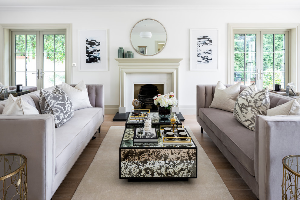 Photo of a traditional open plan living room in London with white walls, light hardwood flooring, a standard fireplace, a stone fireplace surround, no tv and beige floors.