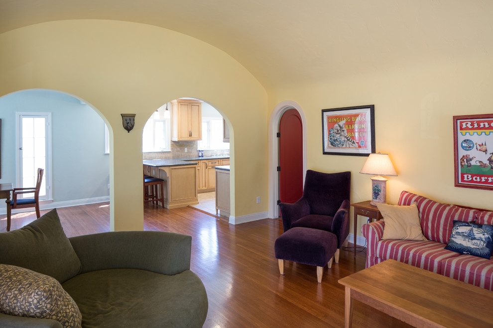 На фото: парадная, открытая гостиная комната среднего размера в средиземноморском стиле с желтыми стенами, паркетным полом среднего тона, стандартным камином, фасадом камина из штукатурки и отдельно стоящим телевизором