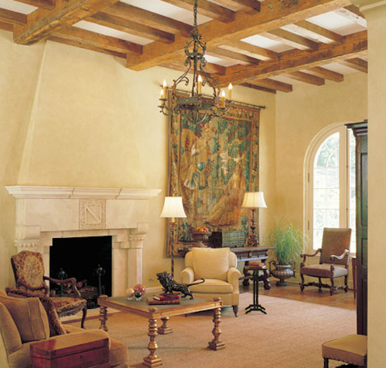 Modelo de salón cerrado mediterráneo grande con paredes beige, suelo de baldosas de terracota, todas las chimeneas y marco de chimenea de piedra