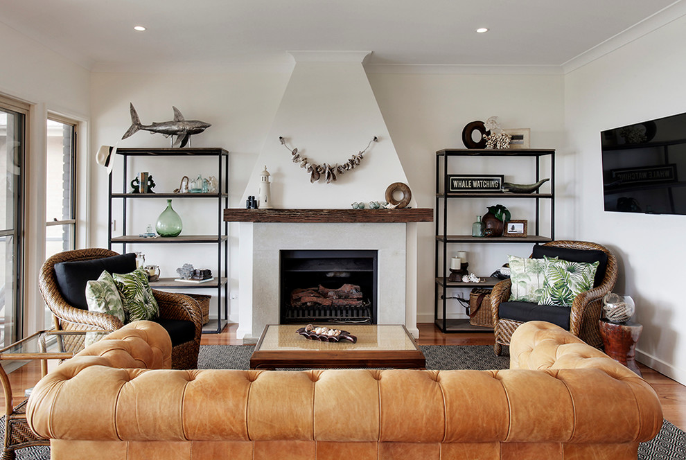 Immagine di un soggiorno stile marinaro con pareti bianche, parquet chiaro, camino classico e TV a parete