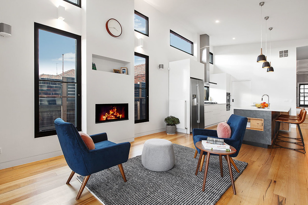 Großes, Repräsentatives, Offenes Modernes Wohnzimmer mit weißer Wandfarbe, braunem Holzboden, Gaskamin, verputzter Kaminumrandung und beigem Boden in Melbourne