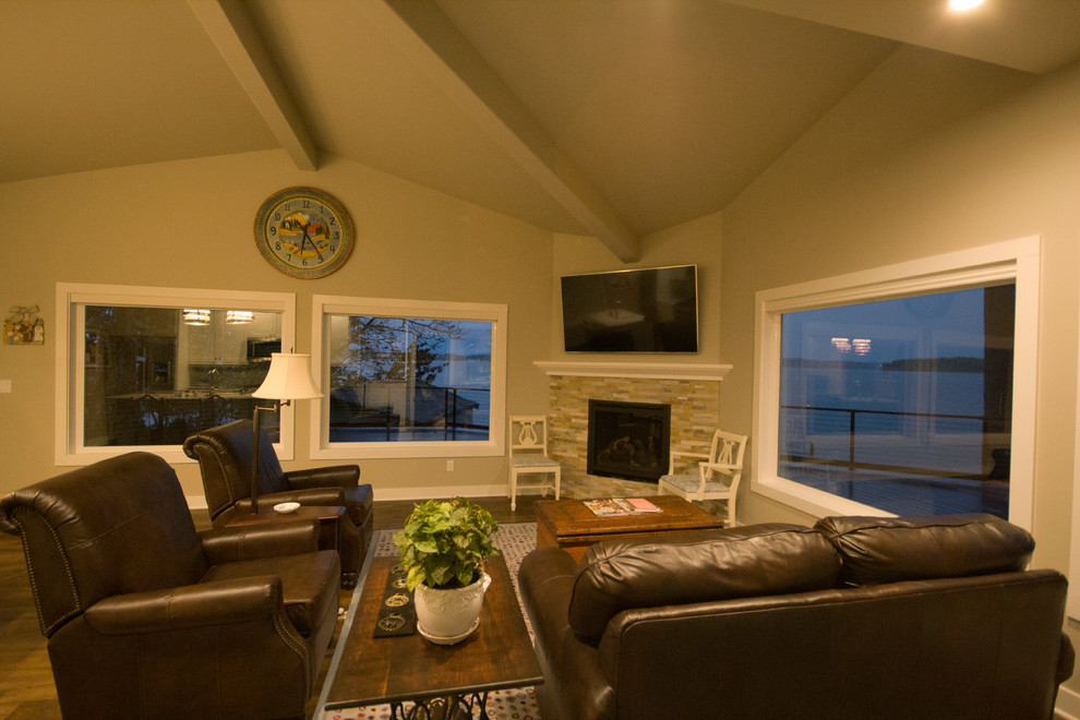 シアトルにある高級な小さなビーチスタイルのおしゃれなLDK (グレーの壁、クッションフロア、コーナー設置型暖炉、石材の暖炉まわり、壁掛け型テレビ) の写真