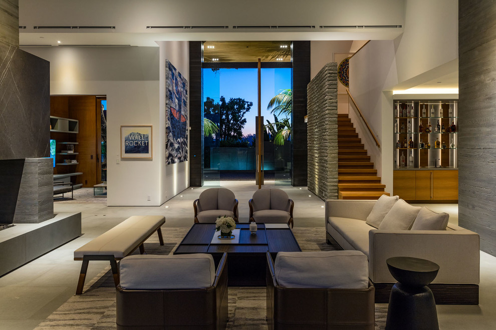 Großes, Offenes Modernes Wohnzimmer mit Hausbar, weißer Wandfarbe, Betonboden, Tunnelkamin, Kaminumrandung aus Beton und grauem Boden in Los Angeles
