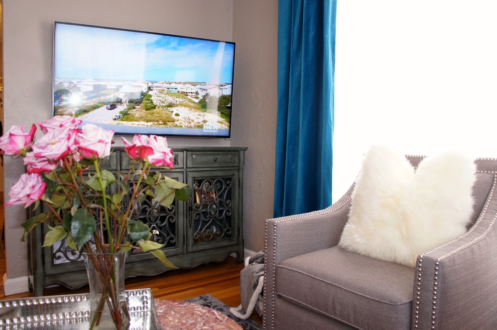 Exempel på ett mellanstort eklektiskt separat vardagsrum, med grå väggar, ljust trägolv och en väggmonterad TV