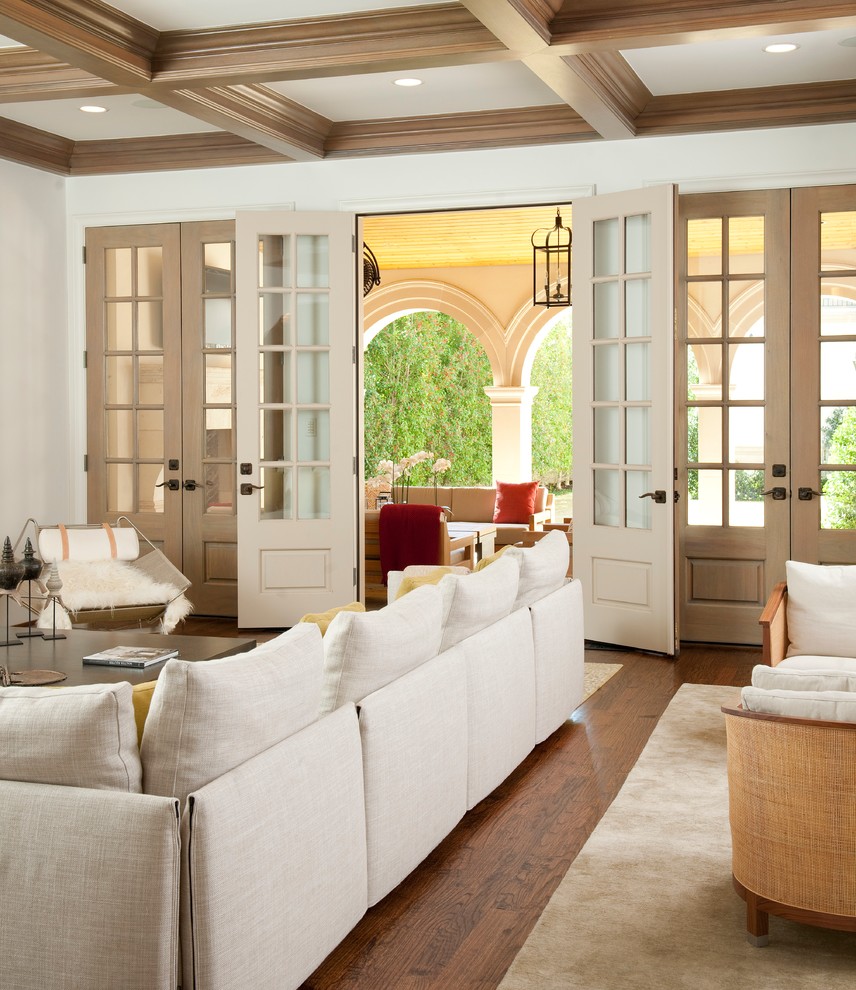 Mediterranes Wohnzimmer mit weißer Wandfarbe und braunem Holzboden in Dallas