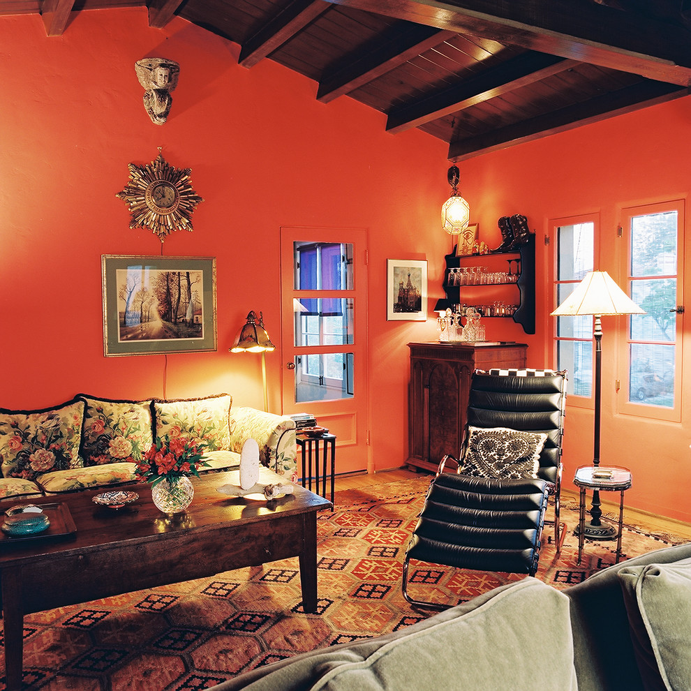 Eklektisk inredning av ett mellanstort separat vardagsrum, med en hemmabar, ljust trägolv och orange väggar