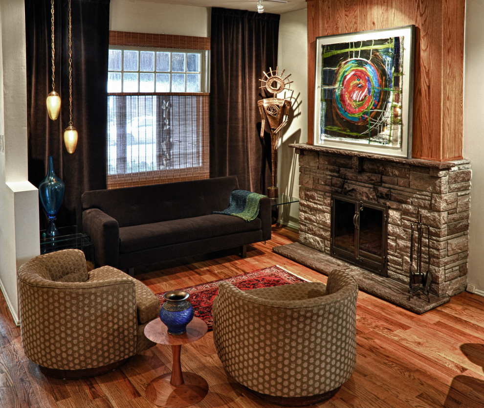 トロントにある中くらいなエクレクティックスタイルのおしゃれなリビング (標準型暖炉、石材の暖炉まわり、茶色いソファ) の写真