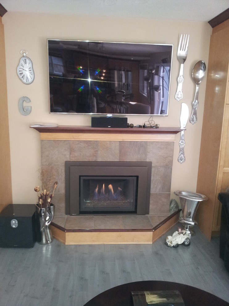 Photo of a medium sized traditional enclosed living room in Vancouver with beige walls, medium hardwood flooring, a standard fireplace, a tiled fireplace surround and a wall mounted tv.