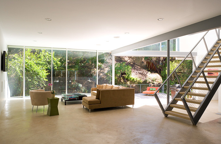 Foto di un soggiorno moderno di medie dimensioni e aperto con pareti bianche, pavimento in cemento, TV a parete e pavimento grigio