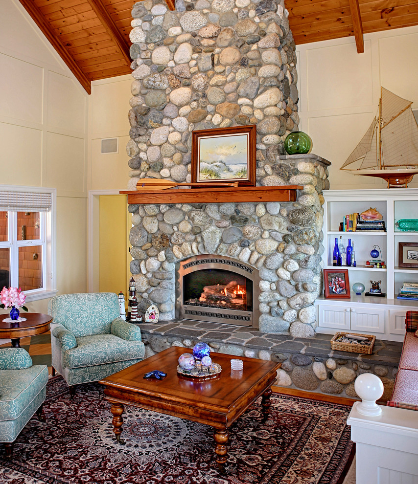 На фото: гостиная комната в морском стиле с стандартным камином и фасадом камина из камня без телевизора