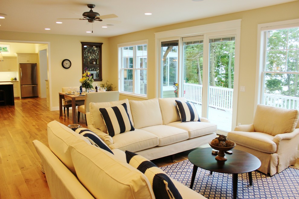 Idee per un soggiorno stile marinaro aperto con pareti beige e pavimento in legno massello medio