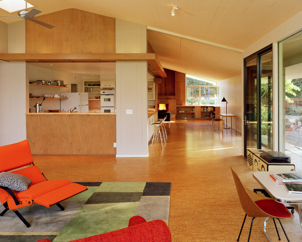 Immagine di un soggiorno minimalista di medie dimensioni e aperto con pavimento in sughero, camino classico e cornice del camino in mattoni