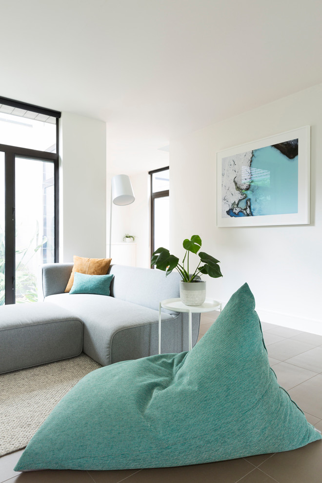 Ispirazione per un soggiorno design di medie dimensioni e aperto con pareti bianche, pavimento con piastrelle in ceramica e pavimento grigio