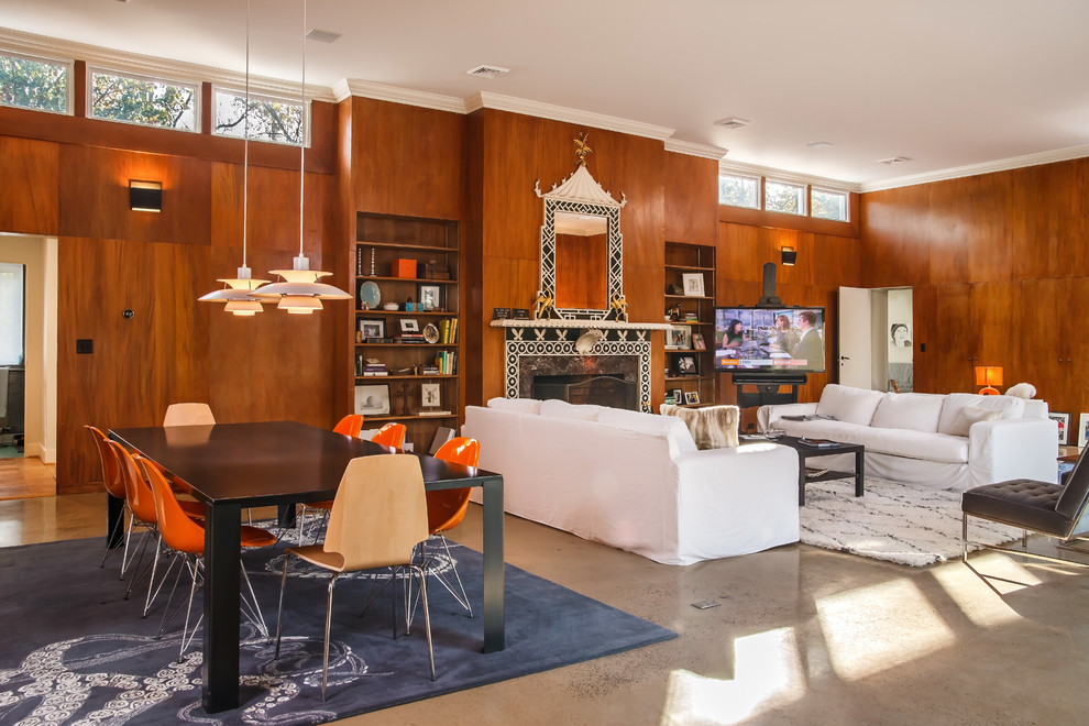 Источник вдохновения для домашнего уюта: большая открытая гостиная комната в стиле ретро с бетонным полом, стандартным камином, фасадом камина из камня, отдельно стоящим телевизором и коричневыми стенами