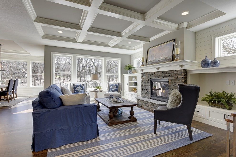 Example of a large transitional open concept medium tone wood floor and brown floor living room design in Minneapolis with gray walls, a standard fireplace, a stone fireplace and a media wall