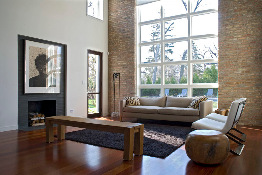 Mittelgroßes, Fernseherloses Modernes Wohnzimmer im Loft-Stil mit weißer Wandfarbe, braunem Holzboden, Kamin und gefliester Kaminumrandung in Chicago