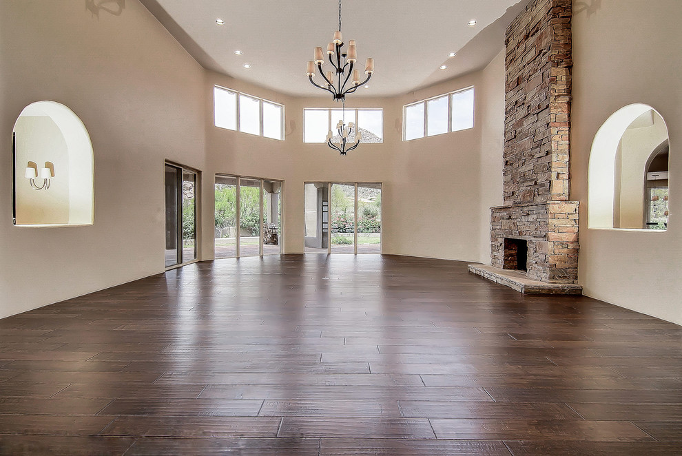 Geräumiges Klassisches Wohnzimmer mit Hausbar, beiger Wandfarbe, braunem Holzboden, Kamin und Kaminumrandung aus Stein in Phoenix