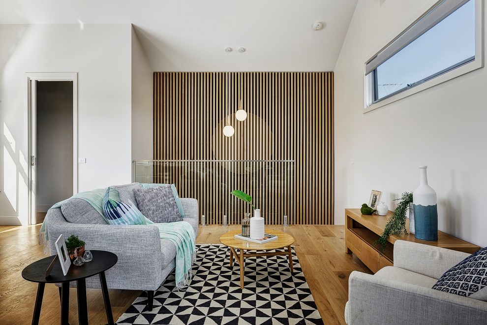 Living room - scandinavian medium tone wood floor and brown floor living room idea in Melbourne with white walls